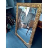 A modern gold painted, wooden framed mirror with a berry and leaf decoration, 106cm x 76cm Location: