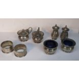 Two white metal napkin rings, together with a pair of white metal mustard pots, salt and pepper