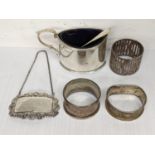 Mixed silver to include a whiskey label, napkin rings, mustard pot and spoons, 136.8g Location: