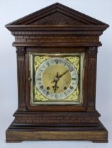 A late 19th century oak mantle clock, the case of architectural design having composite Greek