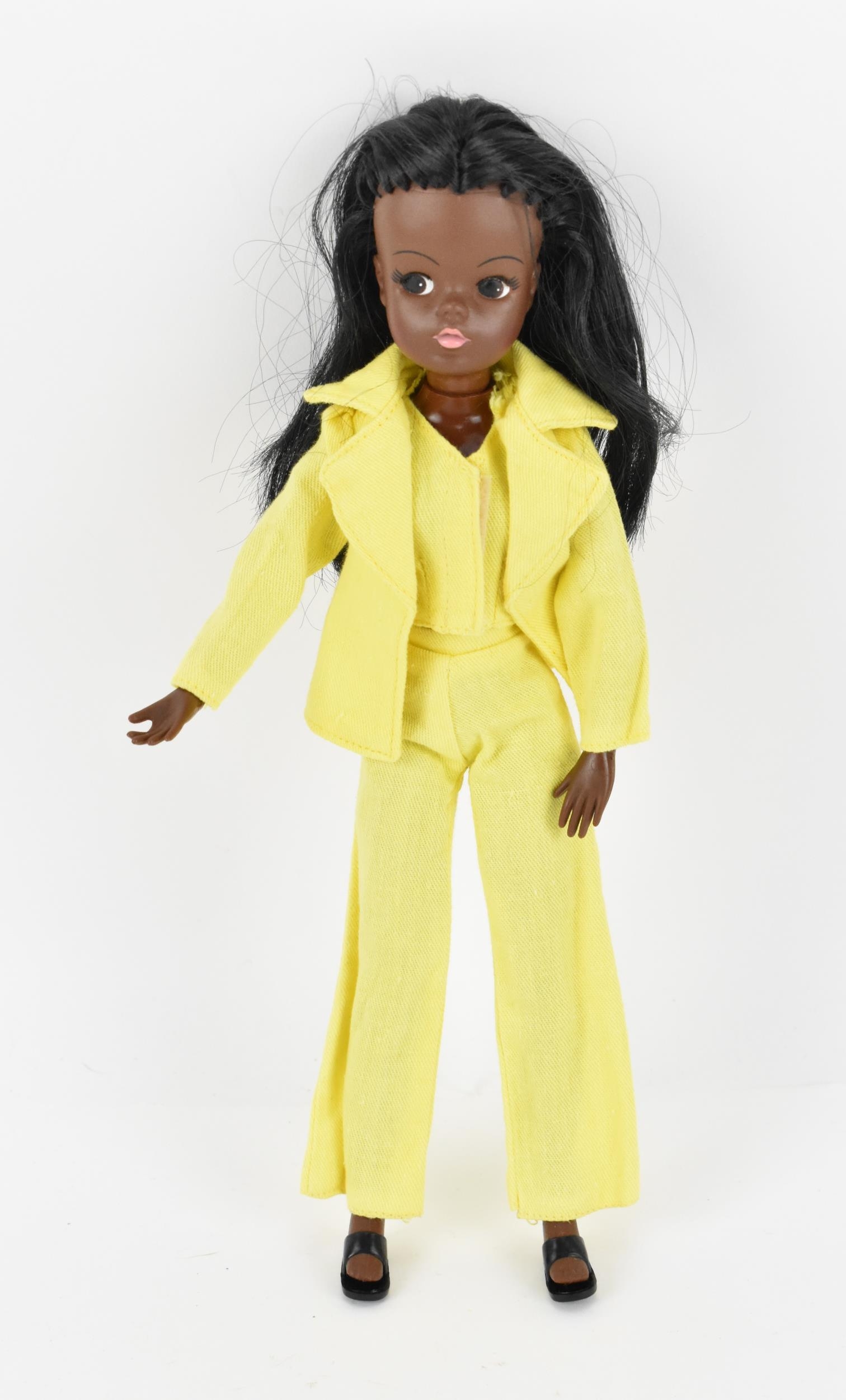 A vintage Sindy's friend Gayle doll in a yellow pant suit, with additional black mules, with painted