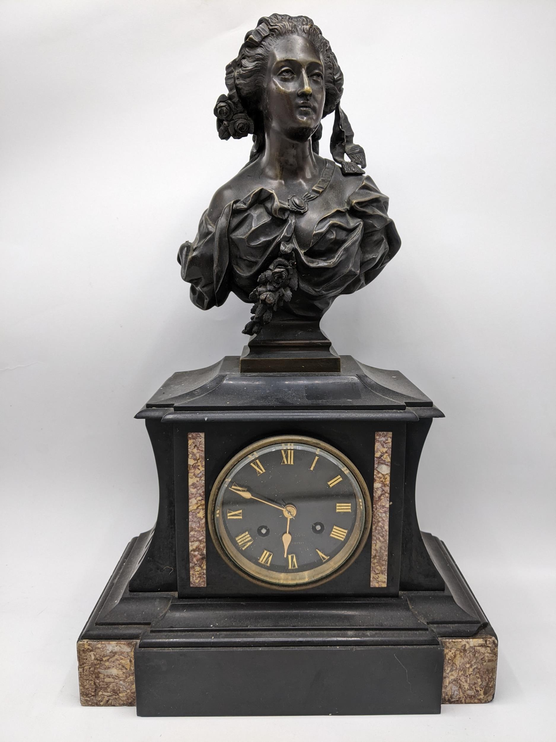 A late 19th century French black slate cased mantel clock surmounted by a bronze bust of a female
