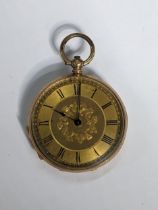 A Victorian 14ct gold, open faced fob watch, having a gilt engraved floral dial, blued hands and