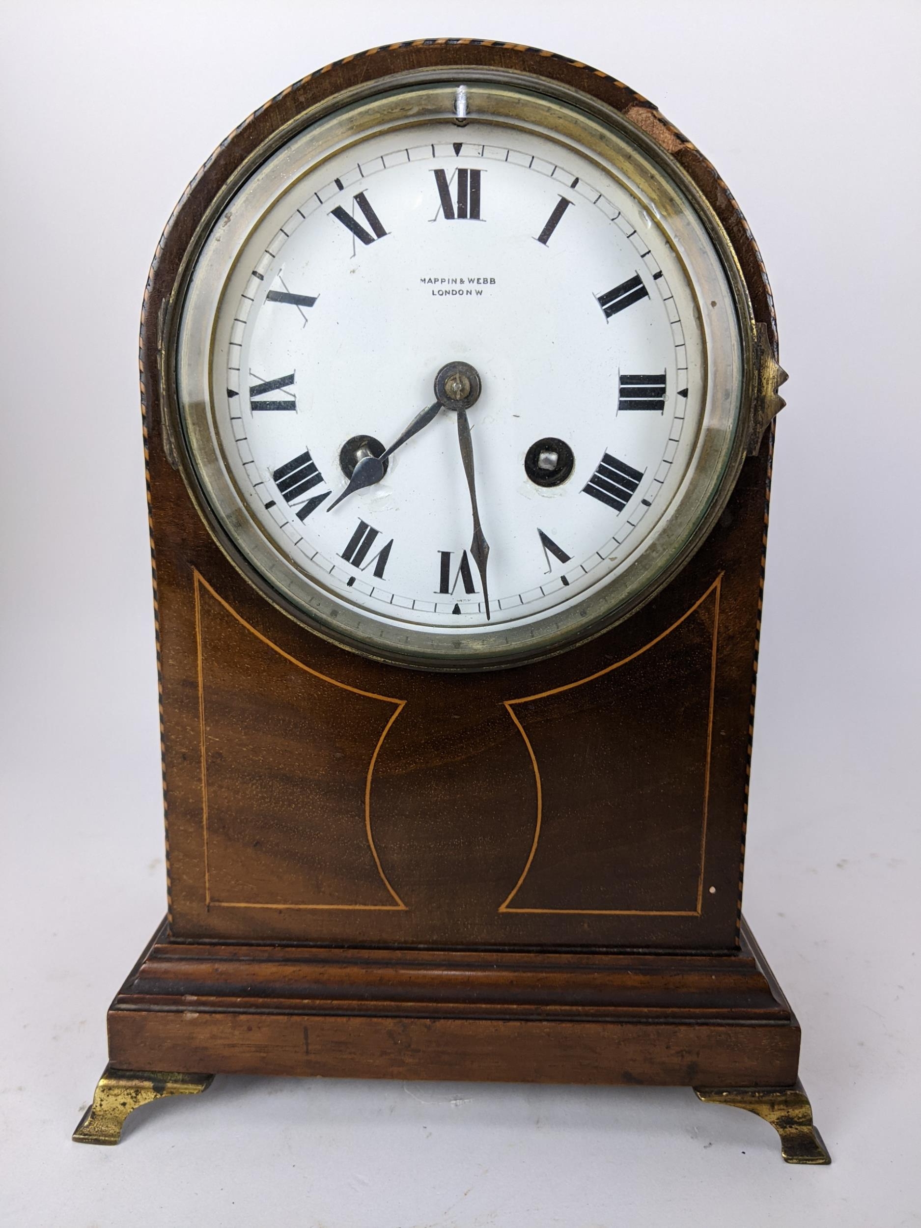 An Edwardian mahogany and string inlaid mantle clock, the white enamel dial having Roman numerals