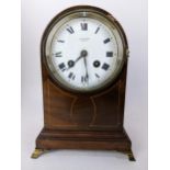 An Edwardian mahogany and string inlaid mantle clock, the white enamel dial having Roman numerals