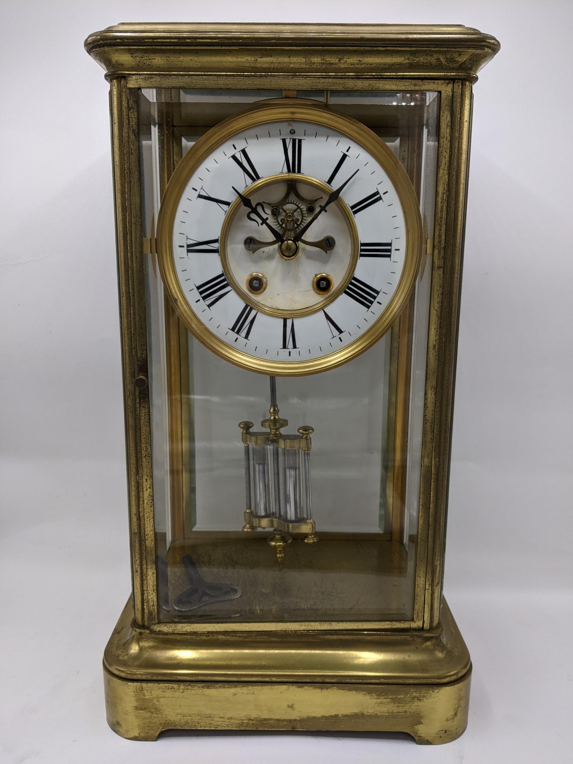 A late 19th century large French gilt brass mantle clock having a white enamel chapter ring with