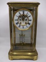 A late 19th century large French gilt brass mantle clock having a white enamel chapter ring with