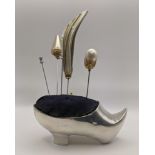 A large Edwardian silver pin cushion/hat pin stand modelled as a shoe, with a turned up toe and