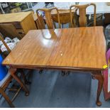 A mid 20th century walnut extending dining table 75.5cm h x 119cm w, together with six Queen Anne