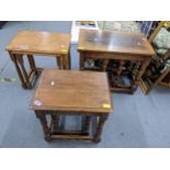 A reproduction oak side table with two slide out tables together with two nests of two tables