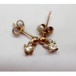 A pair of 9ct gold pierced earrings with a single diamond to each, total weight 0.8g. Location:Cab