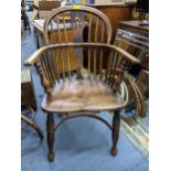 A 19th century elm seated and ash Windsor armchair having spindle back and crinoline stretcher