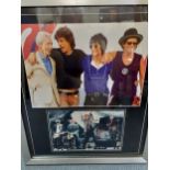 A signed photograph of The Rolling Stones and another unsigned, both mounted in a silver frame, 65cm