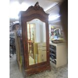 A 19th century walnut single wardrobe with carved pediment, single mirrored door, on carved front