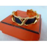 Hermes-A vintage gold tone criss cross cuff bracelet having 4 'X''s with inset smooth black
