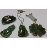 A small group of carved jade and green stone pendants and earrings having gold decoration, pendant