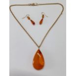 An amber teardrop shaped pendant on an 18ct gold chain, approx weight of chain 9.3g and matched
