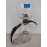 A vintage Cona Size C Genius all glass coffee maker in the Abram Games design Location: R2.4