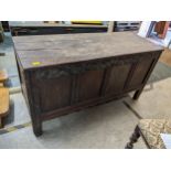 A late 18th century oak carved coffer, four panelled front below a band of carving on stile legs