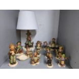 A collection of Goebel figurines to include a figural table lamp in the form of a girl seated