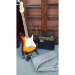 A small Park travel amp together with a modern Encore electric 6 string guitar with stand, travel