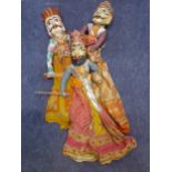 Three Rajasthan hand painted wooden puppets with cloth bodies in brightly coloured textiles.