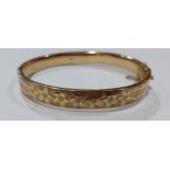 A 9ct gold engraved bangle with safety chain, stamped 375, 9.9g. Location:Cab