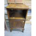 An early 20th century walnut pot cupboard, the top with brushing slide over an open shelf,