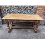 A 17th century style oak refectory ding table having limed oak carved apron and legs, possibly by