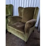 An early 20th century wingback green upholstered armchair Location: