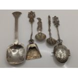 Five continental white metal and sterling silver spoons to include a Dutch tea strainer, 97.6g