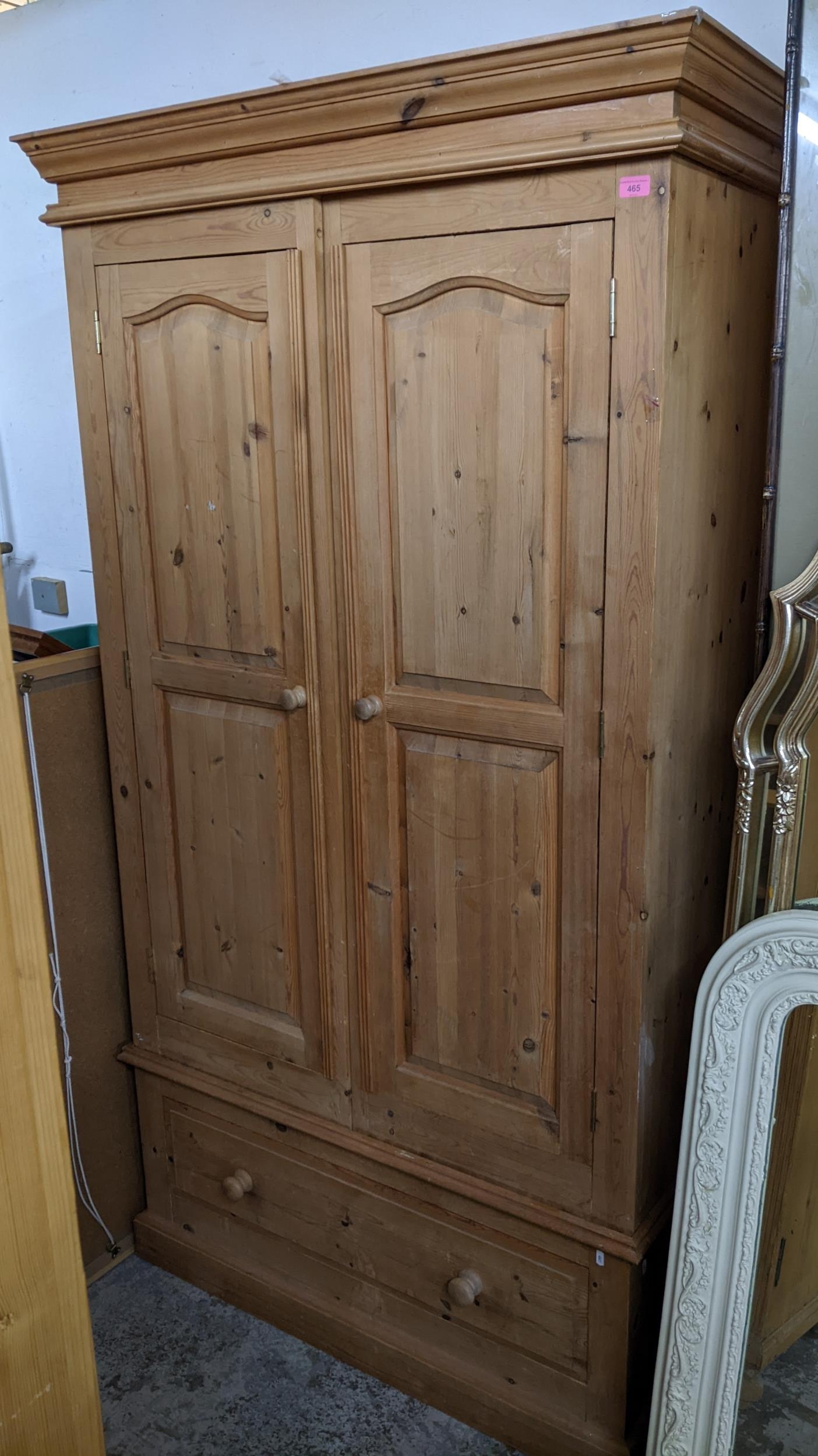 A contemporary pine two-door wardrobe with base drawer on plinth base 200cm x 110cm x 56cm Location: