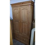 A contemporary pine two-door wardrobe with base drawer on plinth base 200cm x 110cm x 56cm Location: