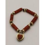 A late 19th/early 20th century yellow metal and carved coral bracelet with heart shaped mourning