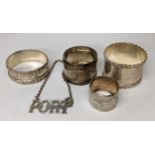 Two sterling silver napkin rings together with two white metal smaller napkin rings, and a port