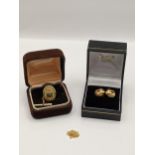 A boxed pair of 18ct gold ear studs 3.1g, together with a 14t gold necklace, 0.6g and a pin badge