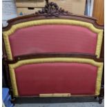 A carved mahogany French upholstered double bed head and footboard, the upholstered panels flanked