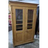 A late 19th/early 20th century pine side cabinet, twin glazed and fielded doors with adjustable
