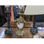 A pair of bronze table lamps having fluted columns together with a gilt table lamp with lion ring