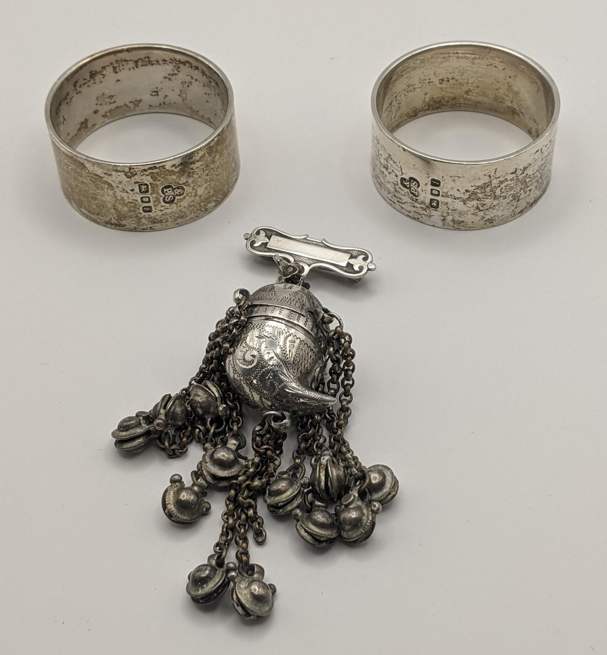 Two silver napkin rings hallmarked London 1964, together with a European folk container brooch