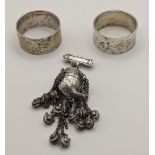 Two silver napkin rings hallmarked London 1964, together with a European folk container brooch