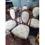Four early 20th Century French walnut dining chairs with cream upholstery with floral sprays.