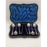 Six silver teaspoons shell shaped, along with a pair of sugar tongs cased hallmarked London 1897,