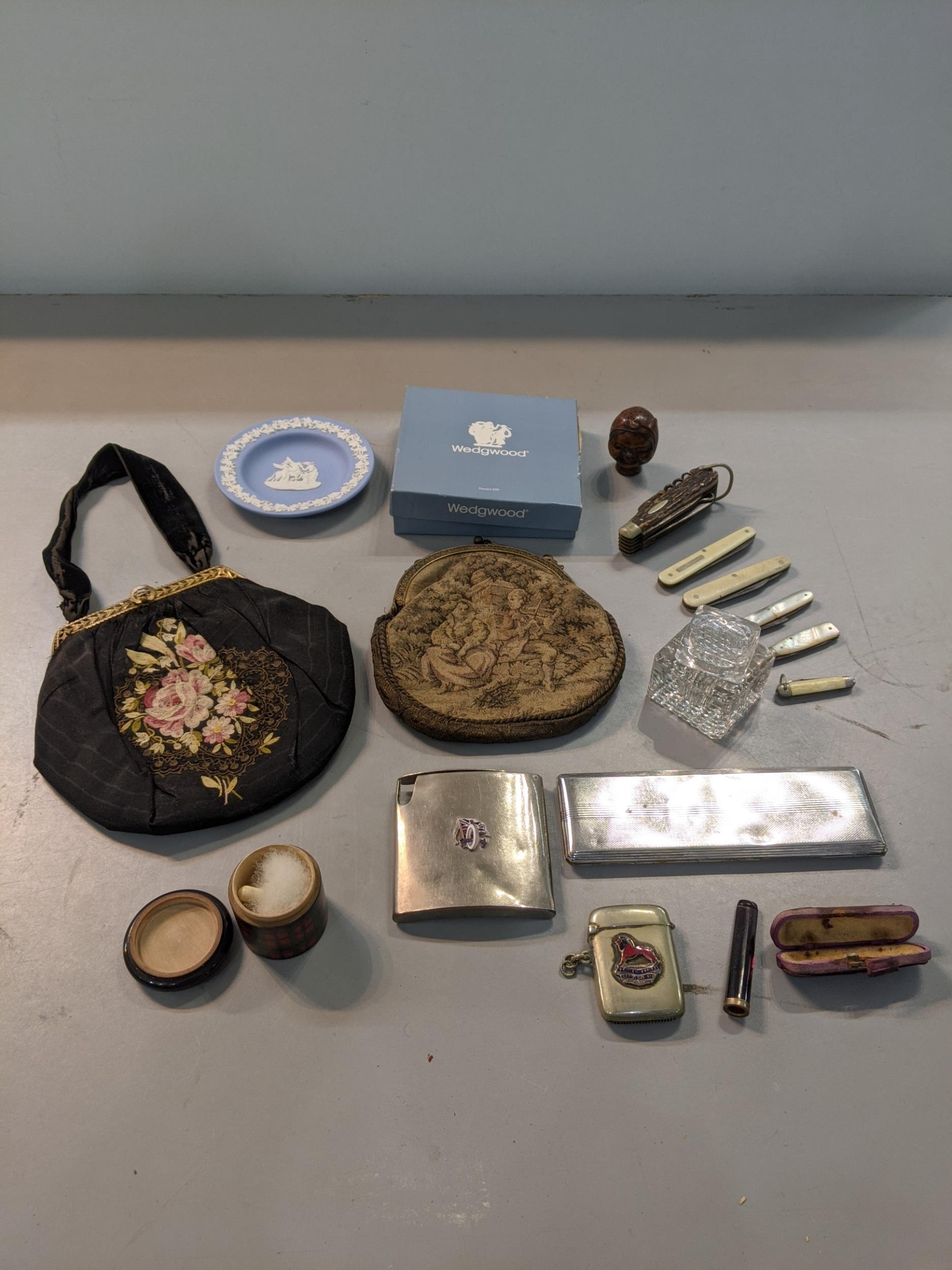 A mixed lot to include a 1930 bag, vesta case, penknives, a cigarette case, dressing table items,