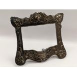 An Art Nouveau sterling silver photograph frame having a floral design, numbered B2829 to the