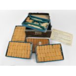 A Chinese leather cased Mahjong bone and bamboo set, the case with four pull out fitted trays