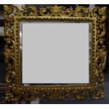 A 19th century Italian giltwood mirror, the square bevelled glass within a c-scroll acanthus frame