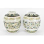 A pair of Chinese Famille Verte ginger jars, decorated in the Kangxi style with leaf tip frieze to