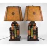 A pair of Maitland-Smith faux book table lamps, with matching chamfered design shades with gilt