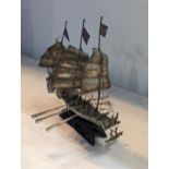 A vintage white metal Chinse style sailboat having three masts and six oars, on treen base Location: